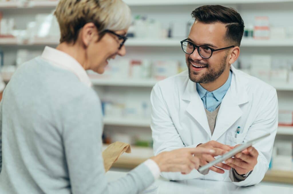 Pharmacist talking to senior patient at the counter